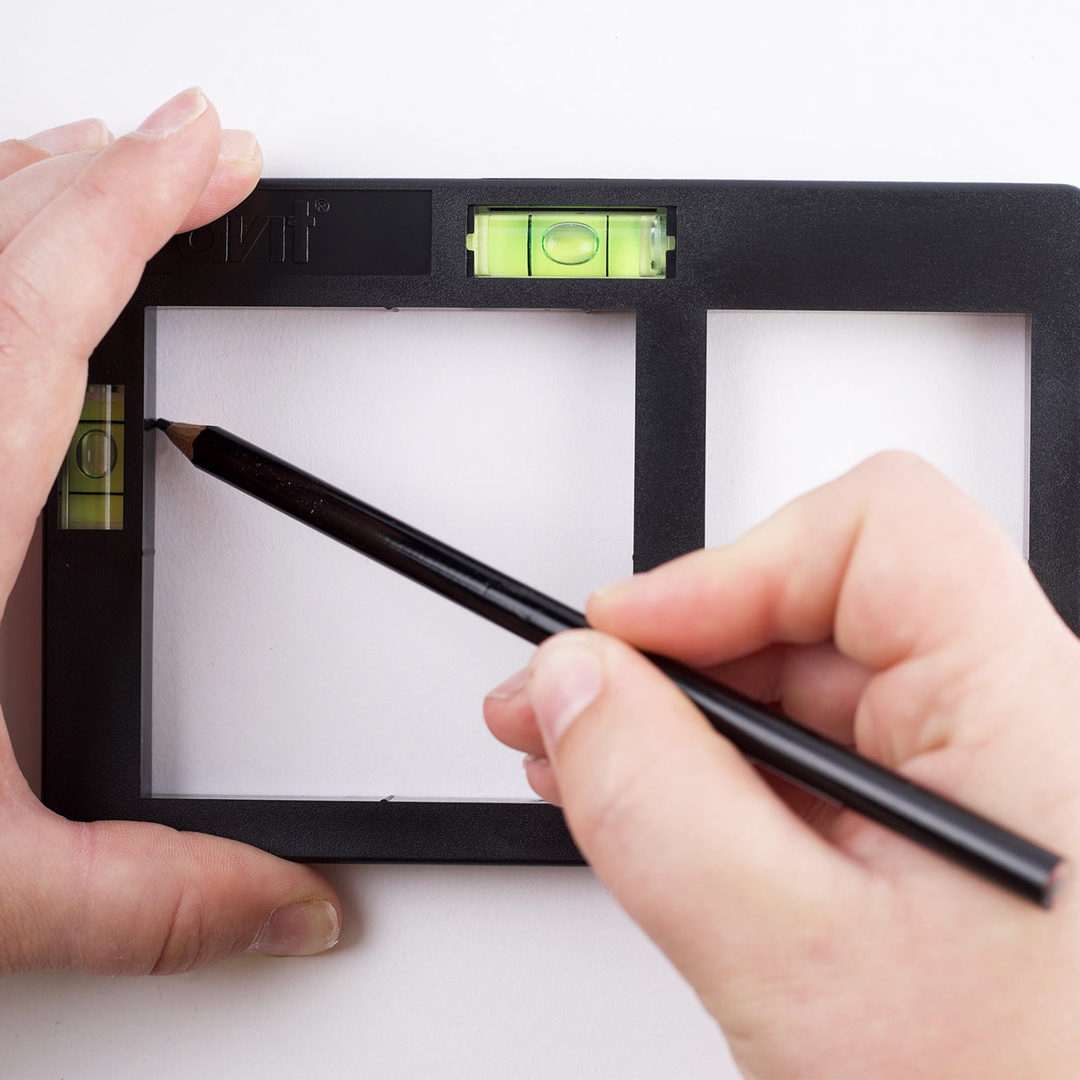 Person using a pencil to demonstate how to use AV02034 socket box template, on a white background
